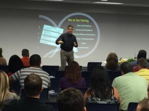 Darren Denington on stage in front of a slide
